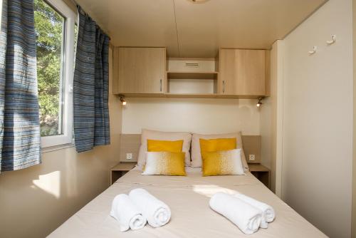Manjadvorci的住宿－Mobile Homes Dvor，一间小卧室,配有带毛巾的床