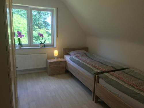 um pequeno quarto com uma cama e uma janela em Schrapper em Grönheim
