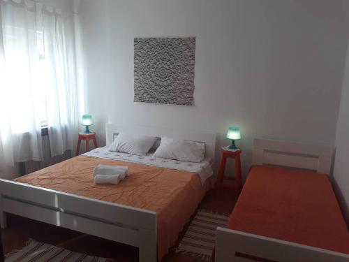 a bedroom with a large bed with two lamps at Apartments Pag Holiday in Pag