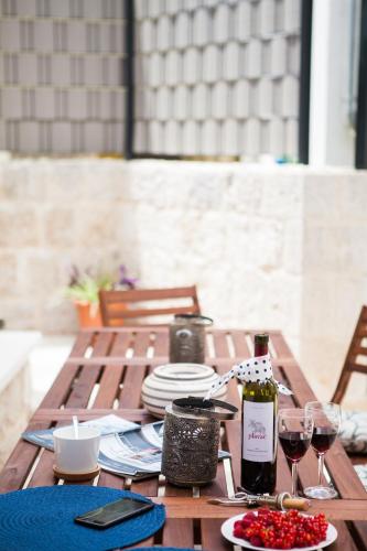 a wooden table with plates and wine glasses on it at Villa Lucia in Trogir