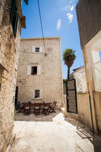 a building with a table and benches in a courtyard at Villa Lucia in Trogir