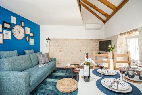 uma sala de estar com um sofá azul e uma mesa em Villa Lucia em Trogir