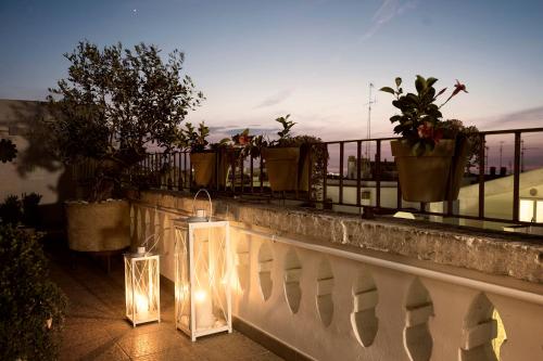 a balcony with potted plants and lights on a fence at La Torre del Tempo in Turi
