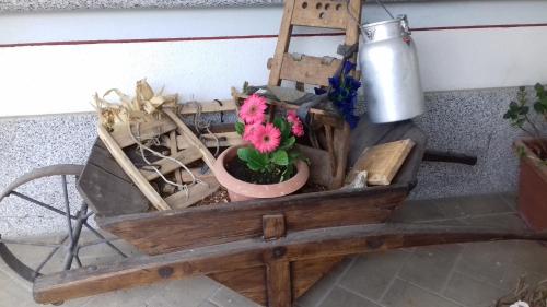 a wooden wagon with a potted plant and flowers in it at B&B Nido Delle Aquile in Monclassico
