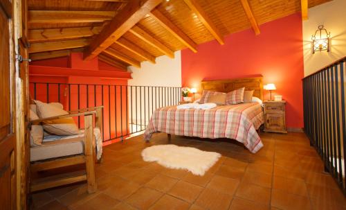a bedroom with a bed and a red wall at El Bulín de Piñuecar in Piñuécar