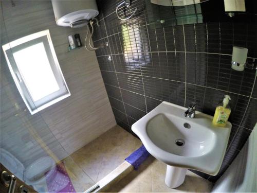 a bathroom with a sink and a window at Family Apartment in Cetinje