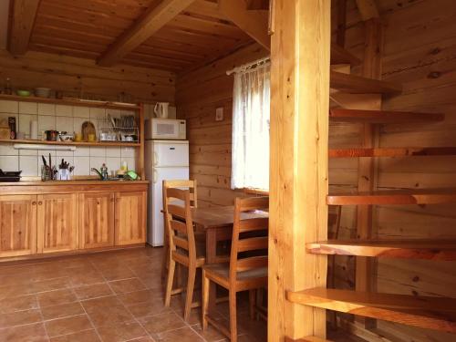 una cocina con mesa y sillas en una cabaña en Kaukiškė, en Antaiksnė