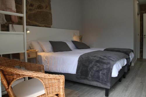 una camera con un grande letto e una sedia di A Finquiña a Pontevedra