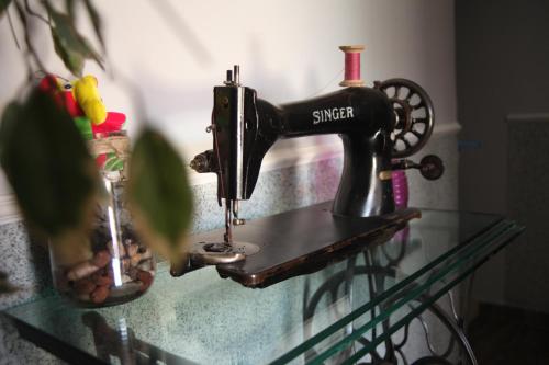 a sewing machine sitting on top of a glass table at Family Apartment in Cetinje