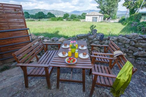 a wooden table with a cake on it with two chairs at El Bulín de Piñuecar in Piñuécar