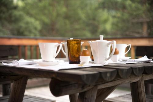 - une table en bois avec des tasses et des ustensiles dans l'établissement Le Passe Montagne, à Uvernet