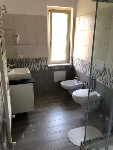 a bathroom with two toilets and a sink and a window at B & B Il Giardino sul Mare in Briatico
