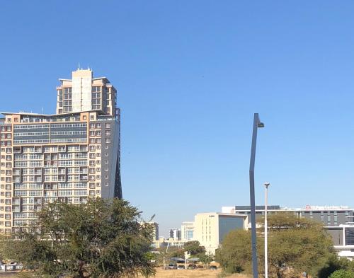 a city skyline with tall buildings and a street light at Urban Awe Apartment-iTowers 23rd Floor in Gaborone