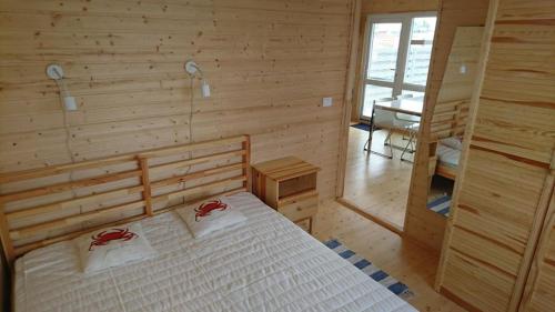 a bedroom with a bed in a wooden room at Pajūrio brizas in Šventoji
