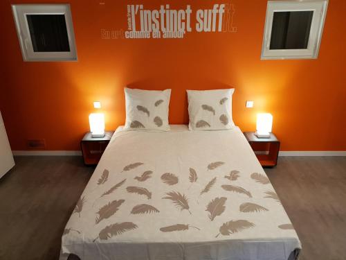 une chambre avec un lit avec un mur orange dans l'établissement Appartement de charme en Provence, à Châteaurenard