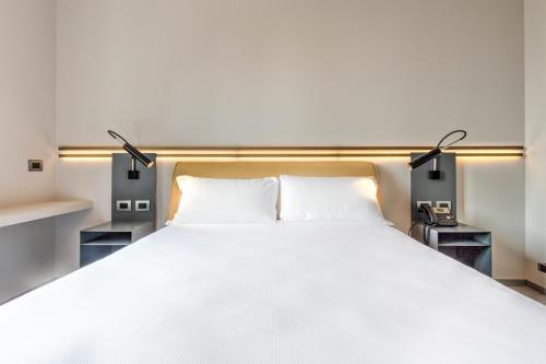 a bedroom with a large white bed with lights at Le Funi Hotel in Bergamo