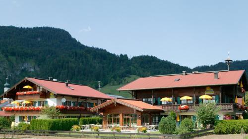 a large building with a red roof on a mountain at Sonnhof's Ferienresidenz in Reit im Winkl