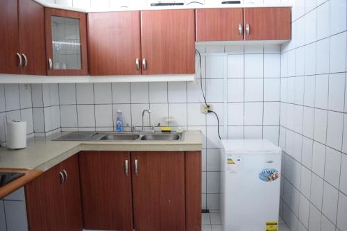 a kitchen with wooden cabinets and a sink and a refrigerator at Alojamiento Verdi, Entre Rios,Guayaquil, Ecuador in Entre Ríos