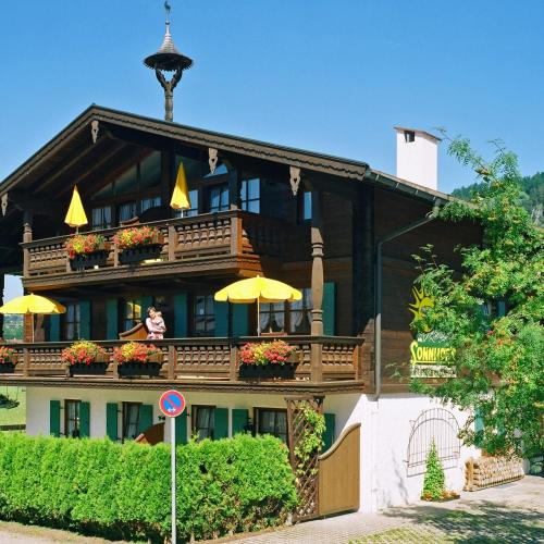 a large building with people sitting on the balcony at Sonnhof's Ferienresidenz in Reit im Winkl