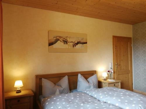 a bedroom with a bed with two lamps and a picture on the wall at Wandertraum Johann - FeWo Eifel in Kruft