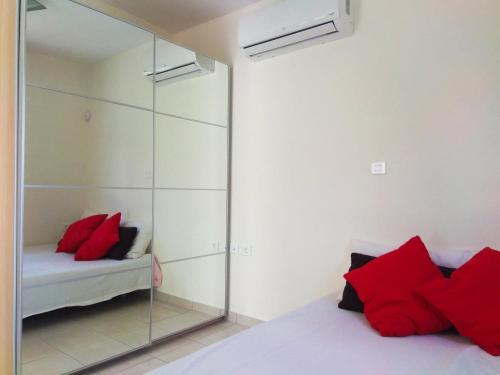 カラモスにあるCosmos Resortのベッドルーム1室(鏡付きのベッド1台、赤い枕付)