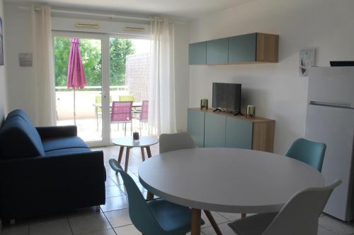 Il comprend une cuisine équipée d'une table et de chaises. dans l'établissement Appartement la Rochelle, à Aytré