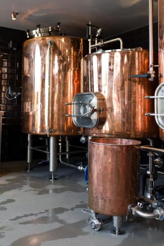a group of large copper tanks in a room at The Peacock at Barlow in Chesterfield
