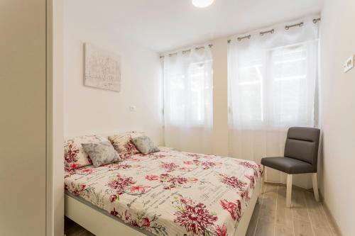 ein kleines Schlafzimmer mit einem Bett und einem Stuhl in der Unterkunft Apartments Luce and Antonio in Split