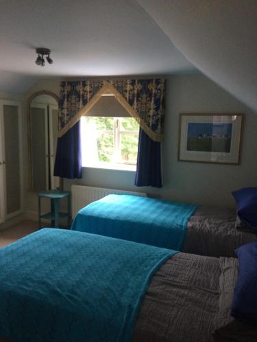 a bedroom with two beds and a window at Tallow House in Ludlow