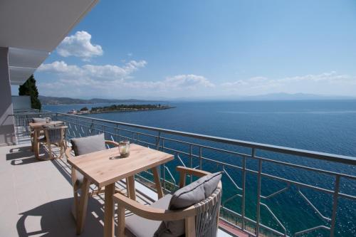 a balcony with a table and chairs and the ocean at Infinity Hotel Gytheio in Gythio
