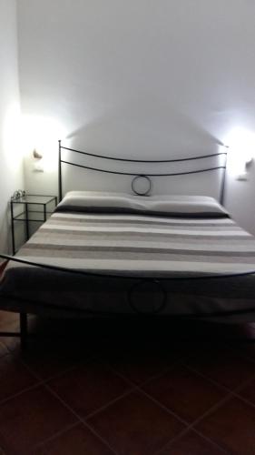 a bed in a room with a white wall at B&B La Vecchia Scuola in Sonnino