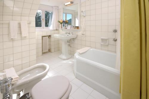 y baño con aseo, lavabo y bañera. en Hotel Tunquelén en San Carlos de Bariloche