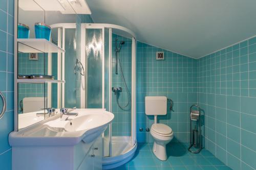 La salle de bains bleue est pourvue d'un lavabo et de toilettes. dans l'établissement Green Garden Apartments, à Medulin