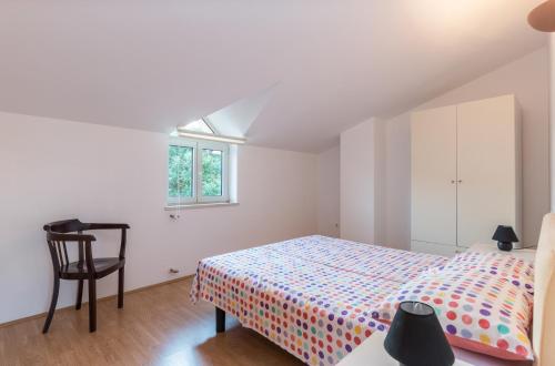 - une chambre avec un lit, une chaise et une fenêtre dans l'établissement Green Garden Apartments, à Medulin