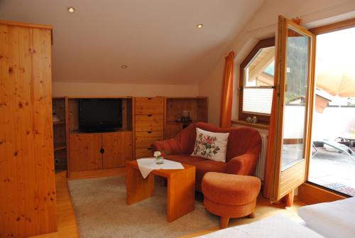 a living room with a chair and a television at Gästehaus Rieser in Mayrhofen