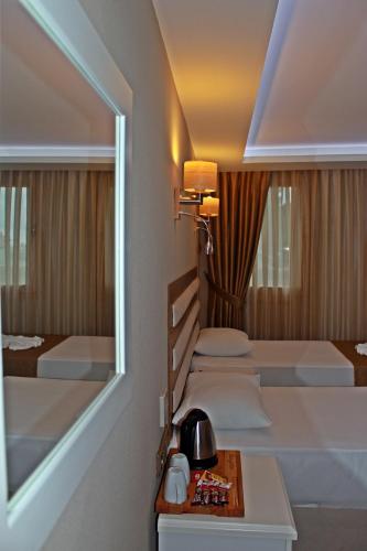 ein Hotelzimmer mit zwei Betten und einem Spiegel in der Unterkunft Feza Otel in Trabzon