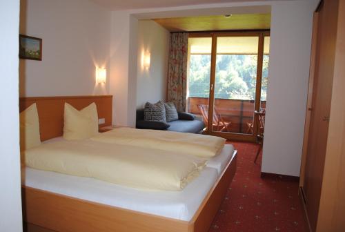 a hotel room with a bed and a balcony at Gasthof Kaiserblick in Breitenbach am Inn