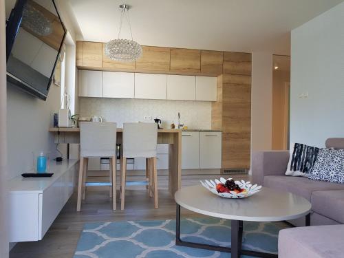 eine Küche und ein Wohnzimmer mit einem Tisch und einem Sofa in der Unterkunft Apartamentdziwnówek in Dziwnówek