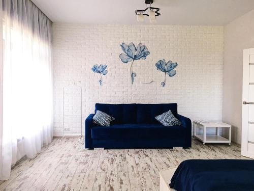 スヴェトロゴルスクにあるApartments Malina Seaの壁のあるリビングルーム(青いソファ付)