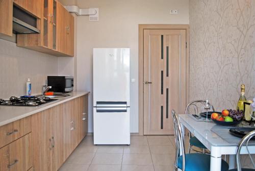 カリーニングラードにあるApartments Malina Cityの白い冷蔵庫付きのキッチン(テーブル付)