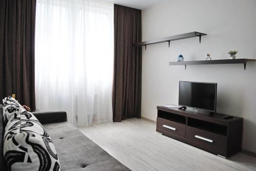 a living room with a flat screen tv and a couch at Apartments Malina City in Kaliningrad