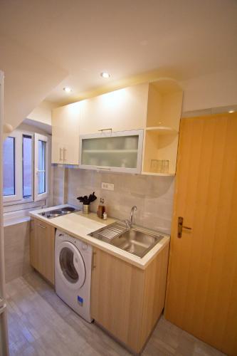 a kitchen with a sink and a washing machine at 3M Peristil in Split