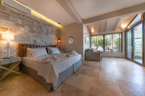 a bedroom with a large bed and a stone wall at Agorastos Suites in Koinyra