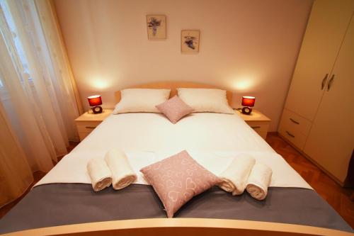 a bedroom with a large white bed with two night stands at 3M Peristil in Split