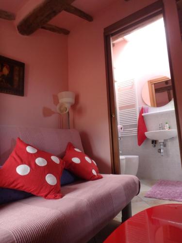 sypialnia z łóżkiem z czerwonymi poduszkami i umywalką w obiekcie The Four Angels w mieście Massa
