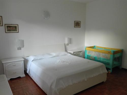 - une chambre avec un lit blanc et une commode dans l'établissement Appartamento Trifoglio, à Salò