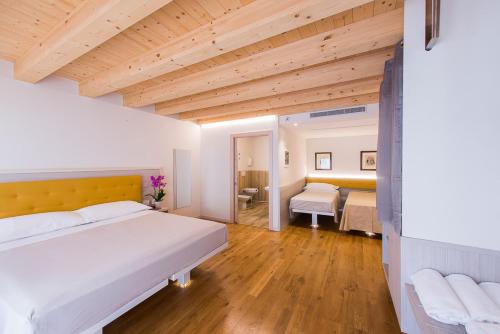 una grande camera con due letti e un soffitto in legno di Residenza Ai Capitelli a Soave