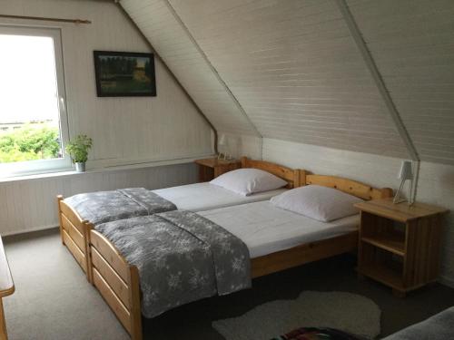 a bedroom with two beds and a window at Domek Wakacyjny in Mikołajki