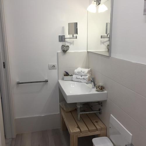 a white bathroom with a sink and a mirror at Residenza Elisa in Desenzano del Garda