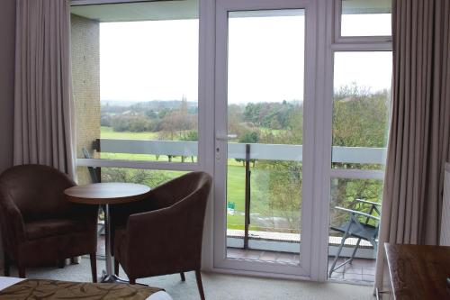 Zimmer mit einem großen Fenster mit einem Tisch und Stühlen in der Unterkunft Humber Royal Hotel in Grimsby